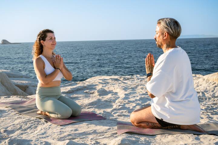 A couple is meditating on Sarakinikos beach, Milos island.